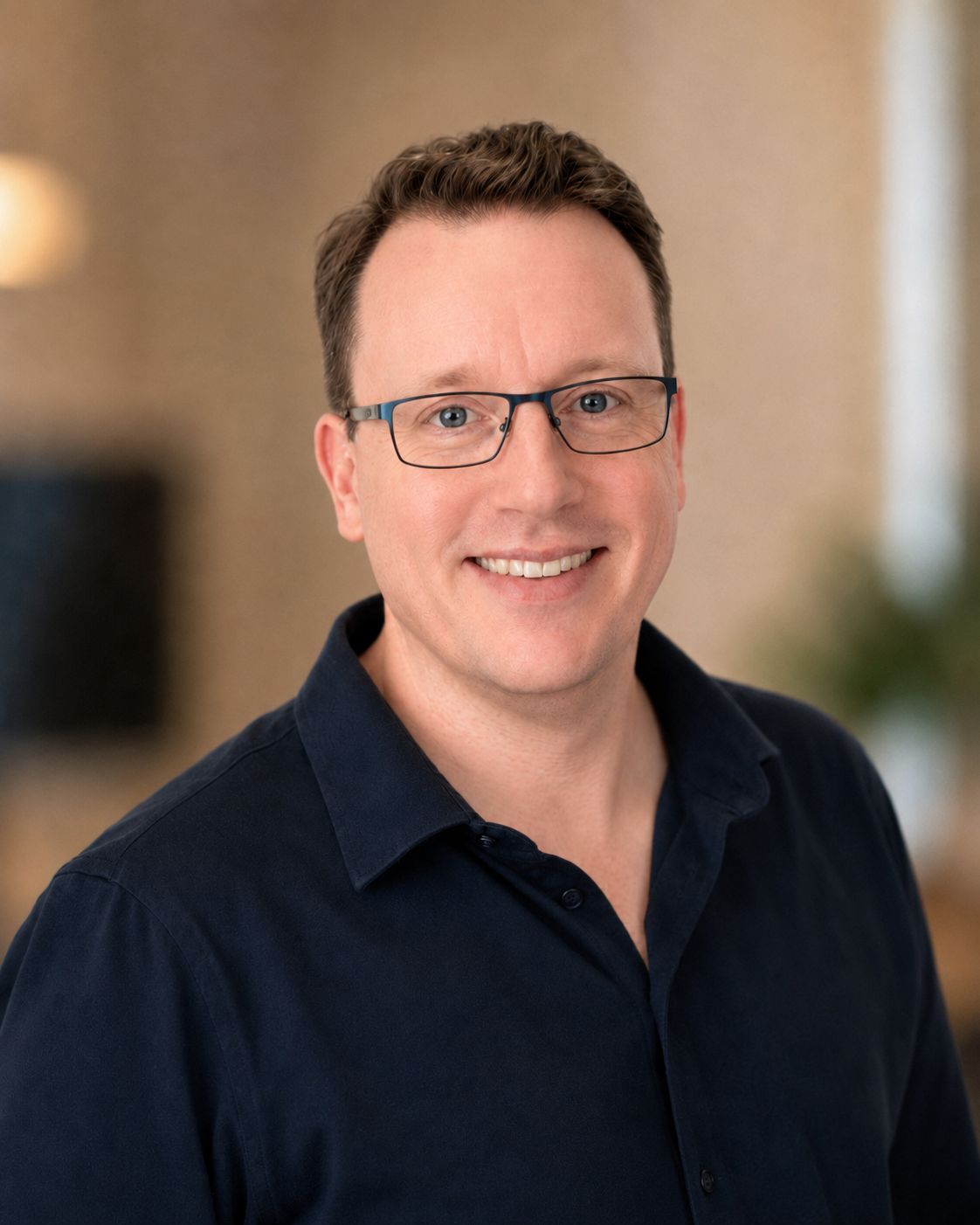 Man in a navy shirt and glasses.
